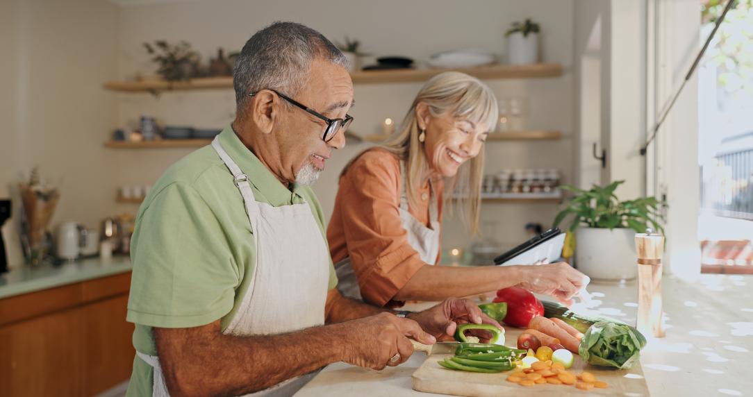 Two older adults preparing food